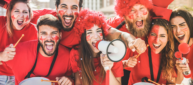 Sports fans together cheering all dressed in red