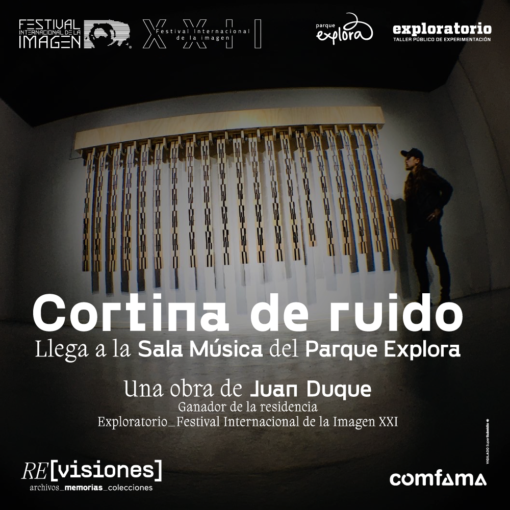 Fotografía. A la derecha de la imagen está el artista Juan Duque de pie. Tiene cabello largo y gorra. Mira de perfil hacia la izquierda donde está su obra, una estructura de madera horizontal de la que salen 20 tiras de madera en forma vertical. En la parte inferior de la imagen texto que dice: "Cortina de ruido llega a la Sala Música del Parque Explora. Una obra de Juan Duque. Ganador de la residencia Exploratorio. Festival Internacional de la Imagen 21".
