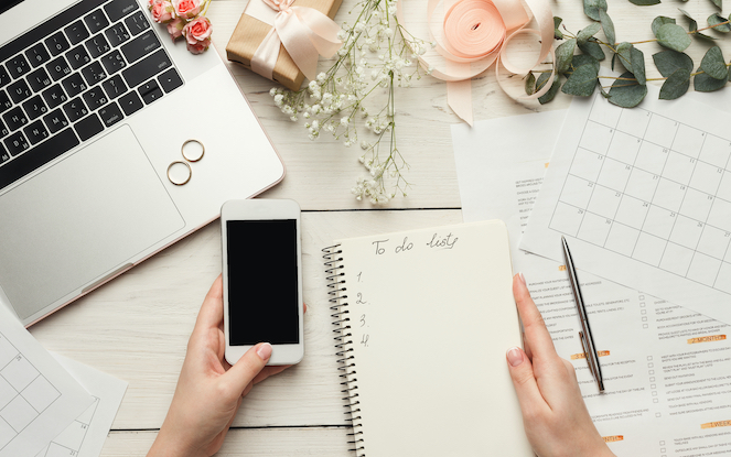 Girl's hands holding phone and To-Do list on desk